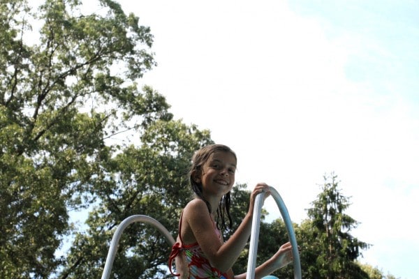 A little girl at the top of a waterslide.