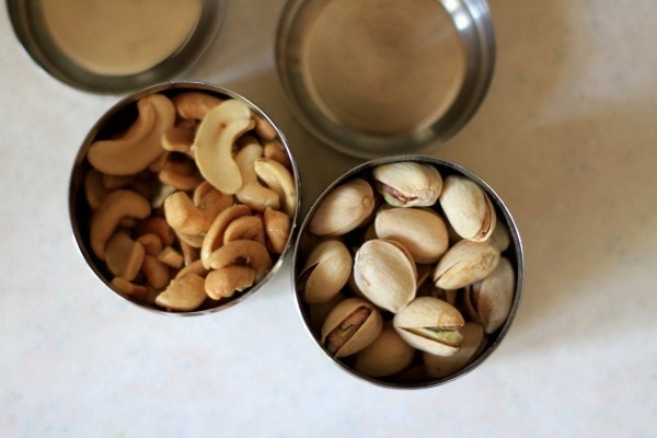 Pistachios and cashews in stainless steel containers.