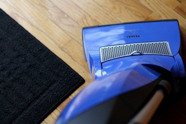 Blue vacuum on a wood floor.