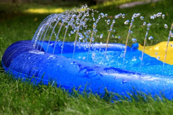 A slip and slide with water squirting out of it.
