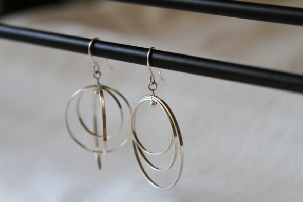 A pair of silver dangly earrings.