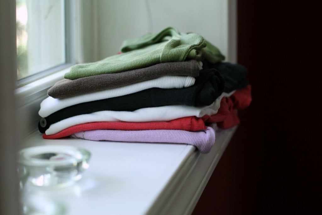 Folded clothes on a window sill.