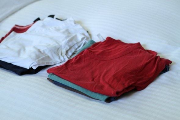 Folded clothes on a bed.