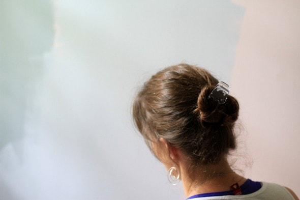 Kristen painting a wall a shade of light blue.