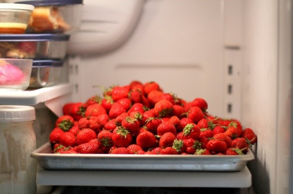 Strawberries piled into a pan in the fridge.