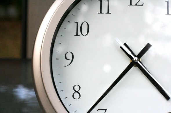 An analog clock with a silver frame.