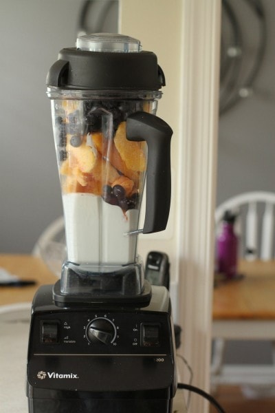 A vitamix blender filled with yogurt and fruit.