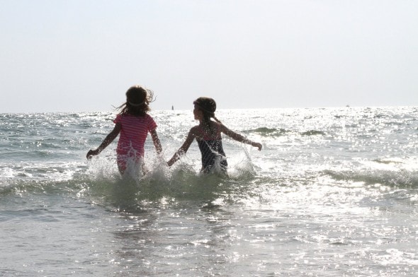 girls jumping in waves