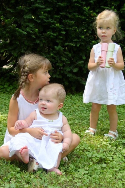 The girls in white dresses in the grass.