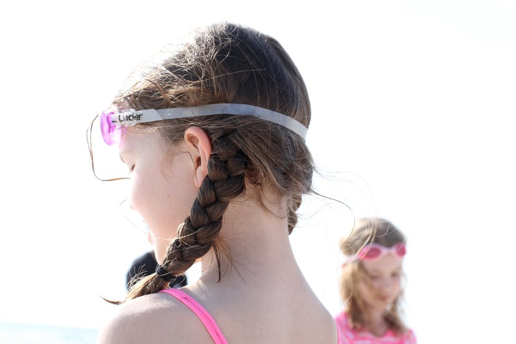 Zoe with braided pigtails and swim goggles.