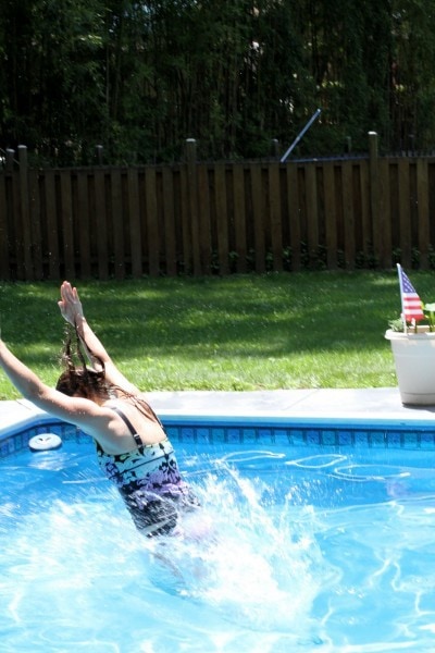 Kristen jumping into a swimming pool.