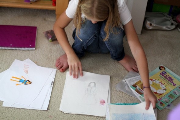 A girl sorting through a pile of papers.