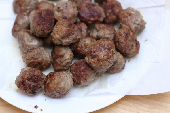 browned meatballs on a paper-towel-lined plate.
