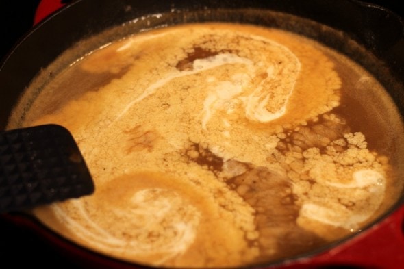 cream swirling into bubbling sauce.