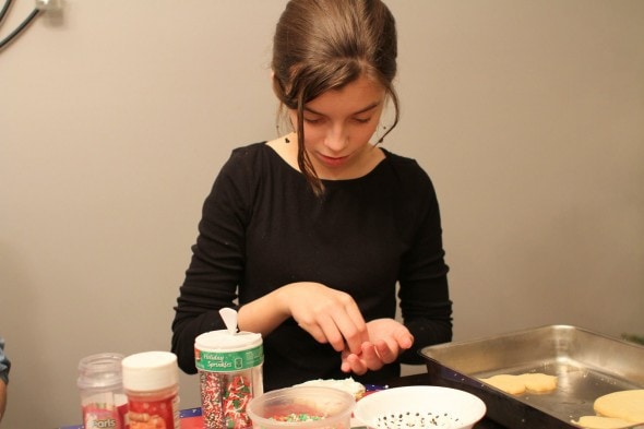 putting sprinkles on christmas cookies