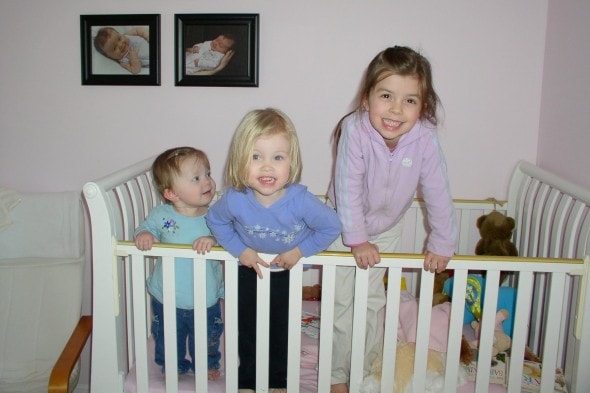 Three girls in a crib.