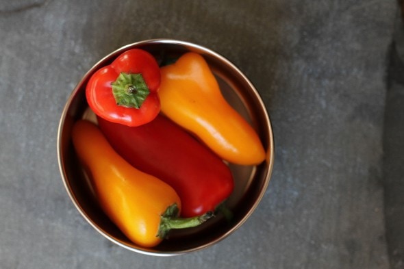 Mini peppers in a stainless steel container.