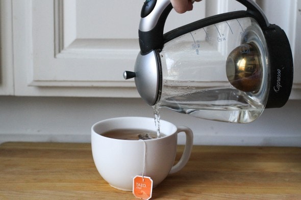 A Capresso electric kettle pouring into a tea cup.