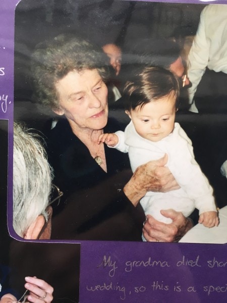 A grandma holding a little girl with dark hair.