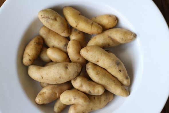 A white bowl of fingerling potatoes.