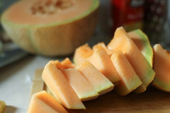 Cantaloupe sliced on a cutting board.