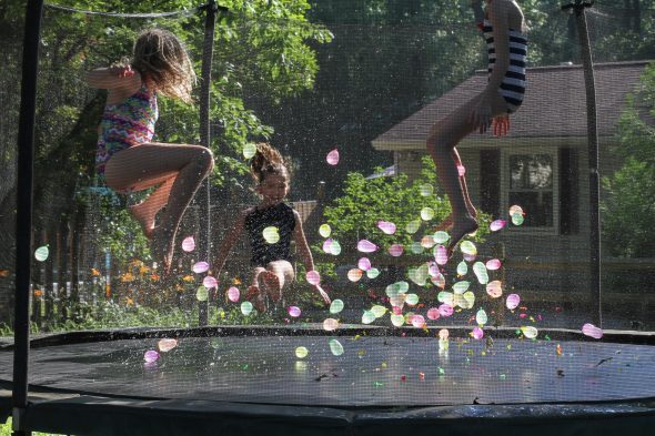 girls on a trampoline with water balloons