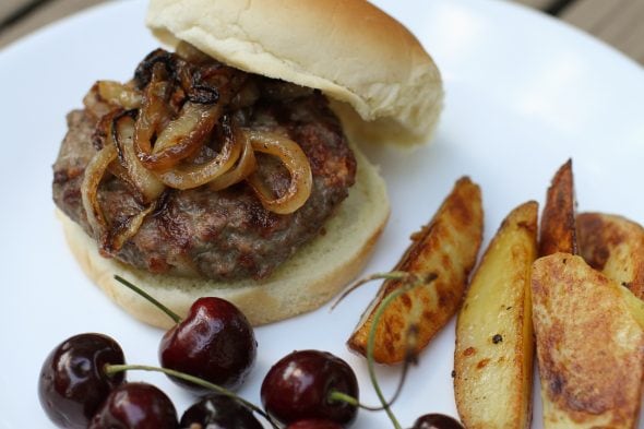 A bacon burger on a white plate.