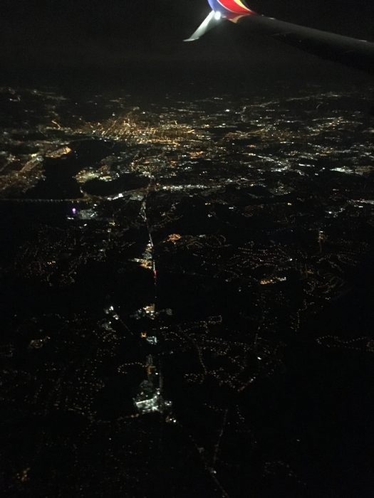 A view of a city at night from a plane window.