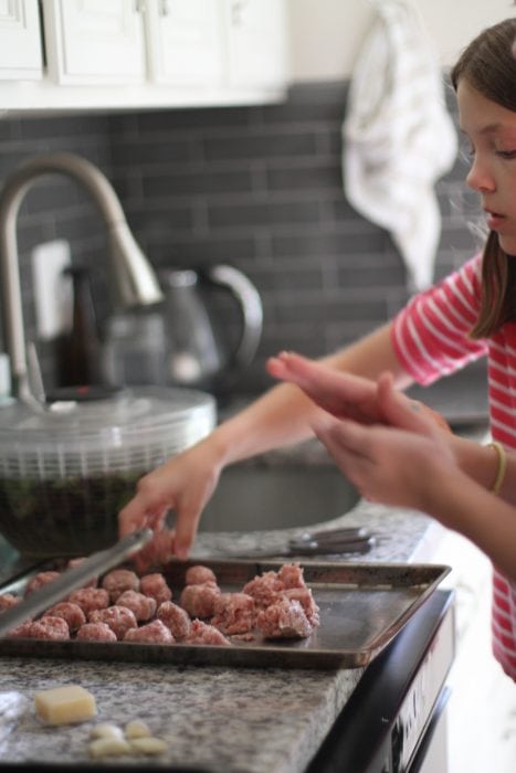 Girls shaping meatballs.
