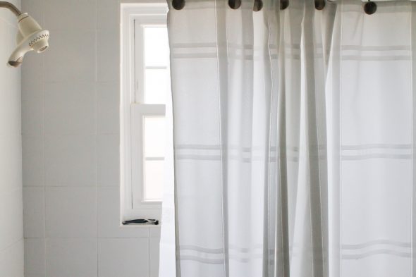 A white bathtub with a white shower curtain.