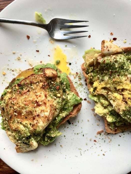 Avocado toast on a white plate.