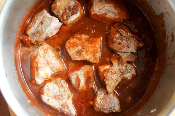 pork chunks in a pot with barbeque sauce.