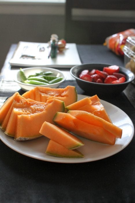 Sliced cantaloupe on a white plate.