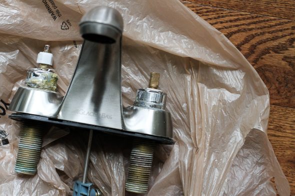 A broken Glacier Bay faucet, on the floor.