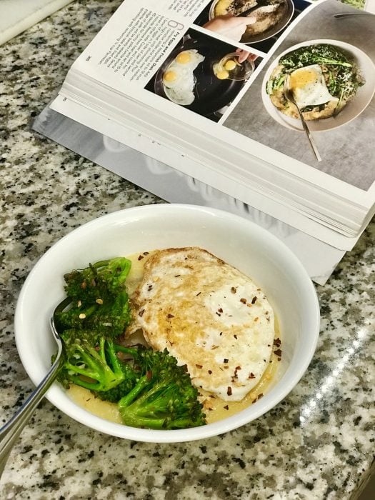 A bowl of polenta, eggs, and broccoli.