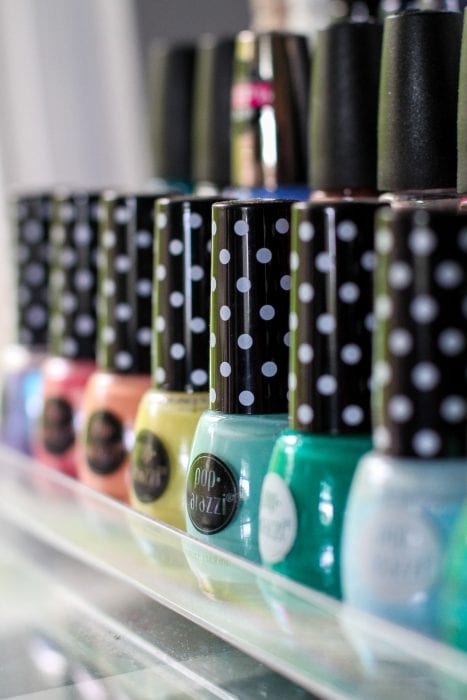 A row of nail polish with polka dotted lids.
