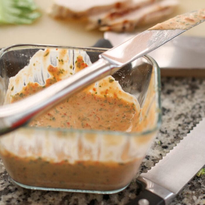 Red pepper and basil mayo in a glass dish.