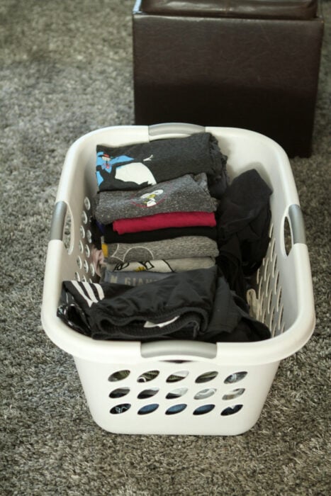 folded laundry in a white basket.