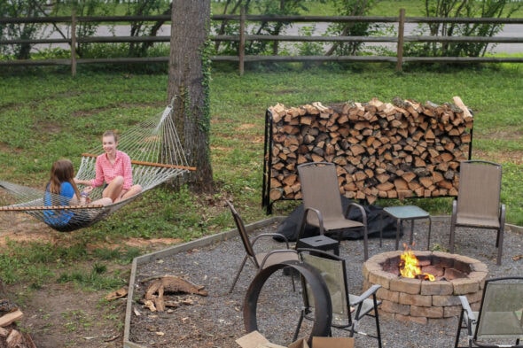 Sonia on a hammock near a fire pit.