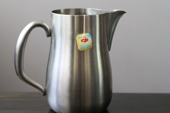 iced tea in a stainless steel pitcher