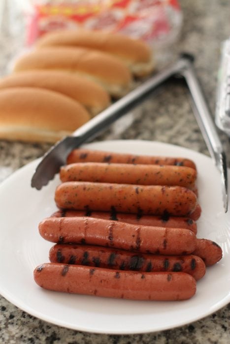 grilled hot dogs on a plate.