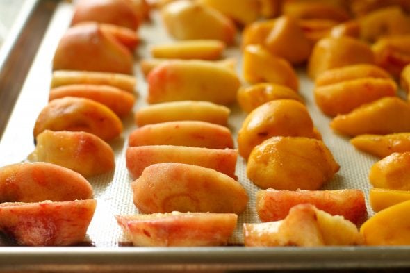 sliced peaches on a tray for freezing
