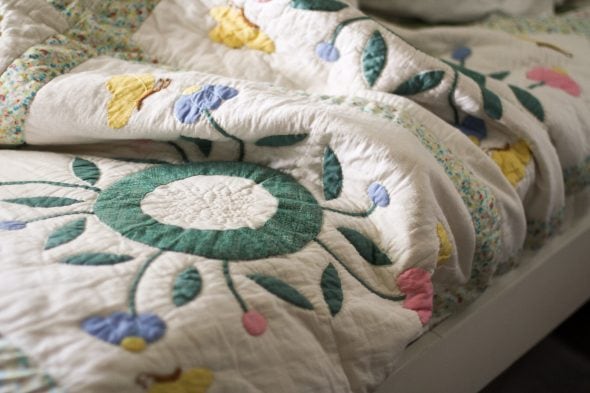 flowered quilt on white twin bed