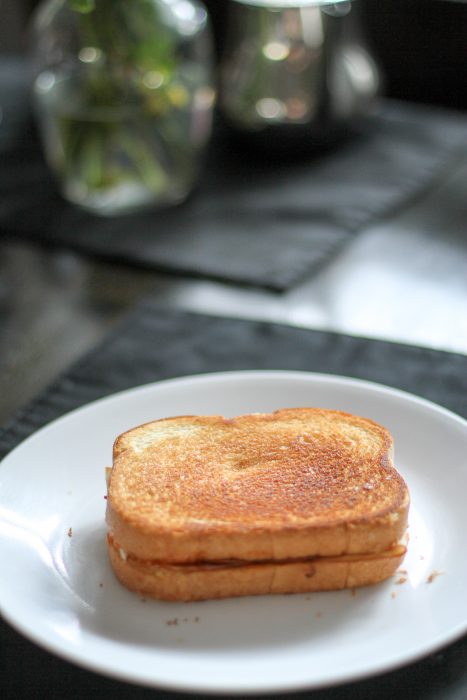 smoked turkey panini sandwich on a white plate.