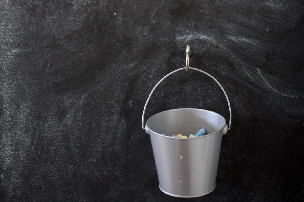 bucket of chalk on chalkboard wall