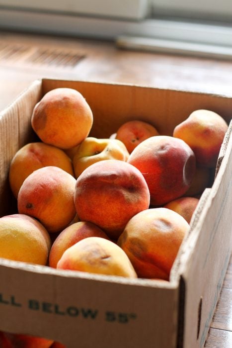 cardboard box of bruised peaches