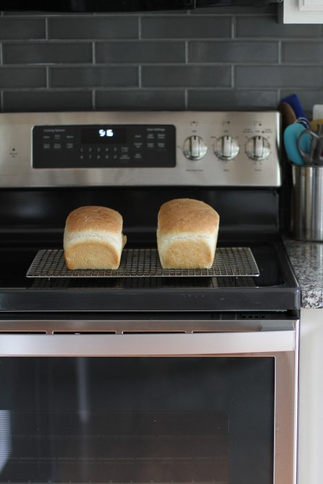 two loaves of white bread on a cooling rack