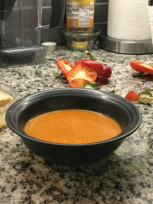 red pepper soup in a black bowl
