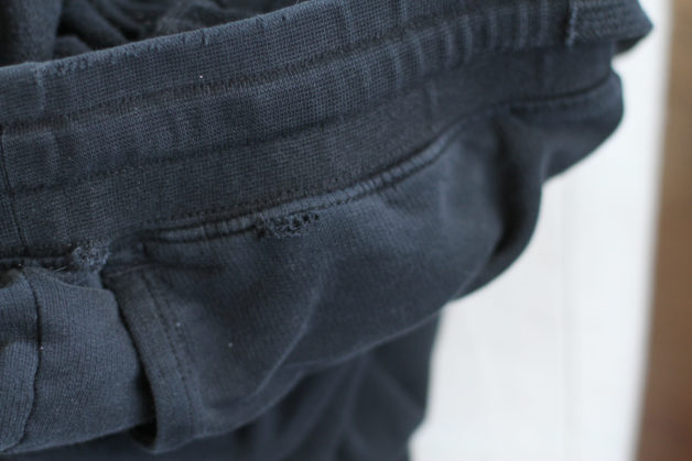 waistband hole in a black pair of American Giant joggers.