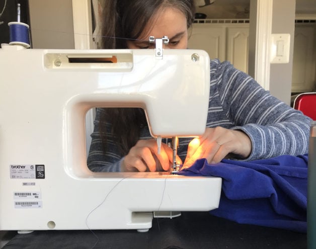 Kristen doing mending on her sewing machine.